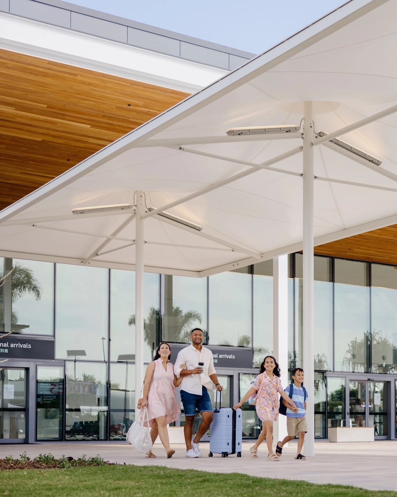 Group of family members exiting through the front exit of Gold Coast airport. Image credit: Queensland Airports