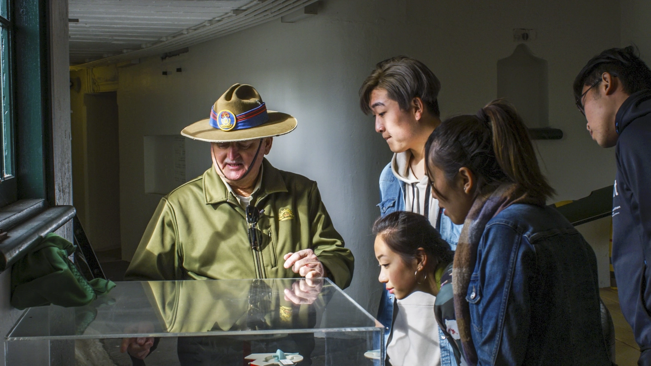 A volunteer in army uniform shows a display to tourists on a guided tour of Fort Scratchley, Newcastle. Image credit: Destination NSW/Eluminate Media