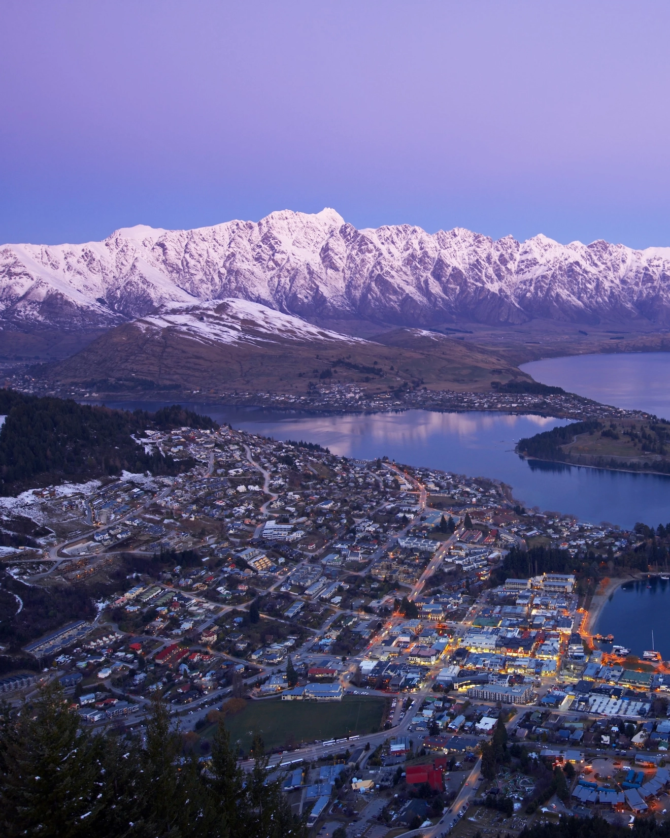 Aerial view of Queenstown and surrounding snow-covered mountains at dusk, New Zealand. Image credit: QueenstownNZ.co.nz