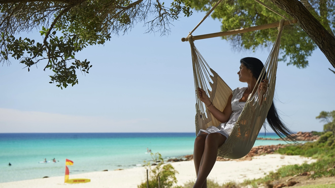 Woman in an upright hammock gazes out at Meelup Beach, Dunsborough. Image credit: Tourism Western Australia.