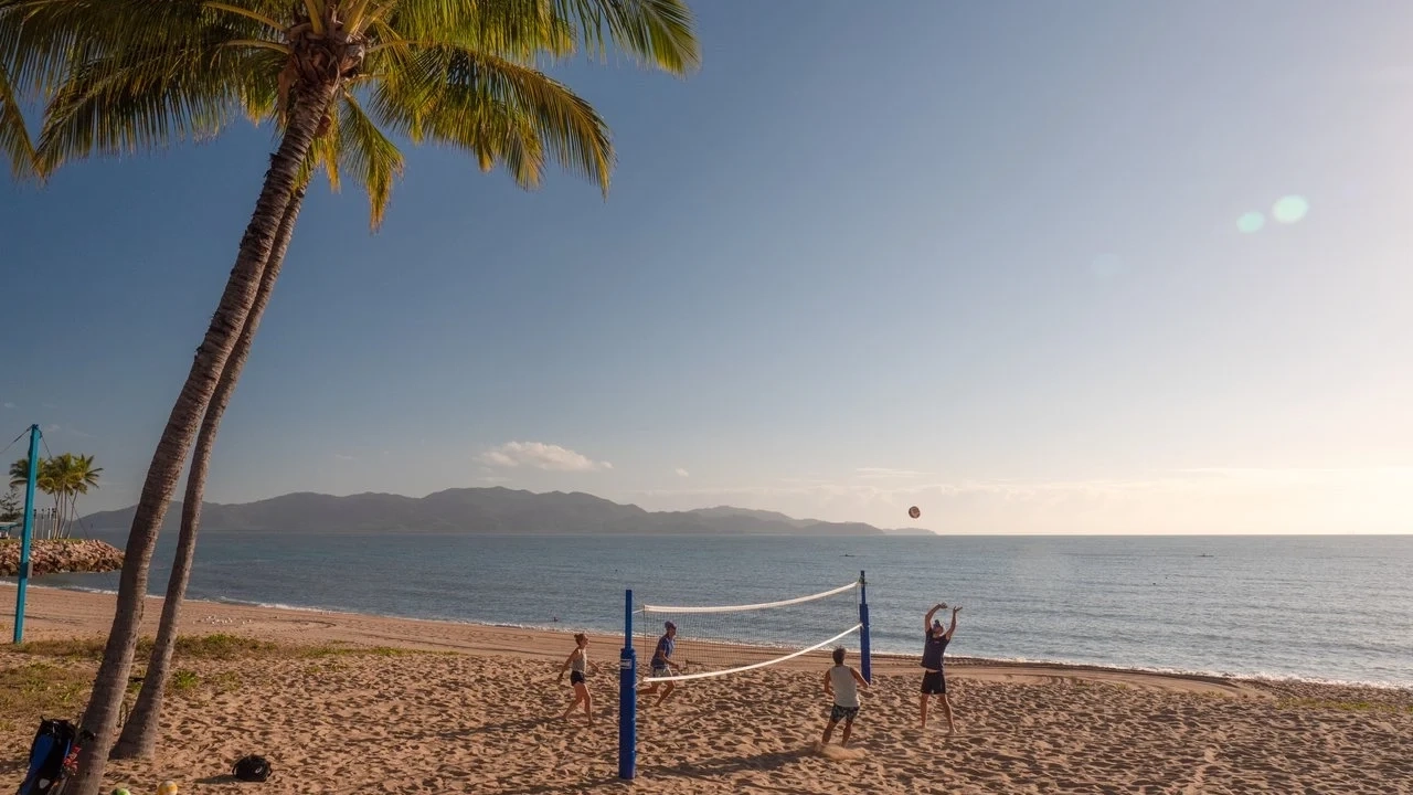 People playing beach volleyball with sea in background. Image credit: Townsville Enterprise