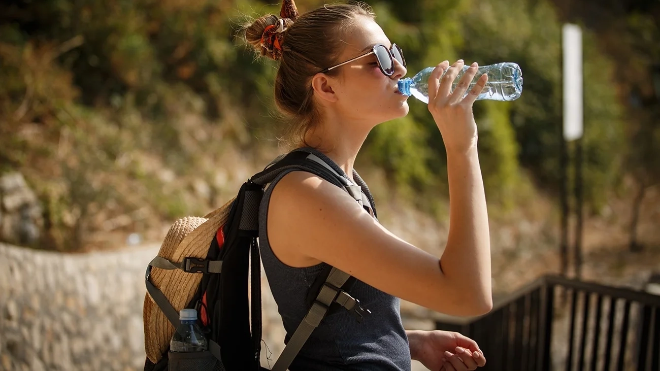 A woman drinks a bottle of water.