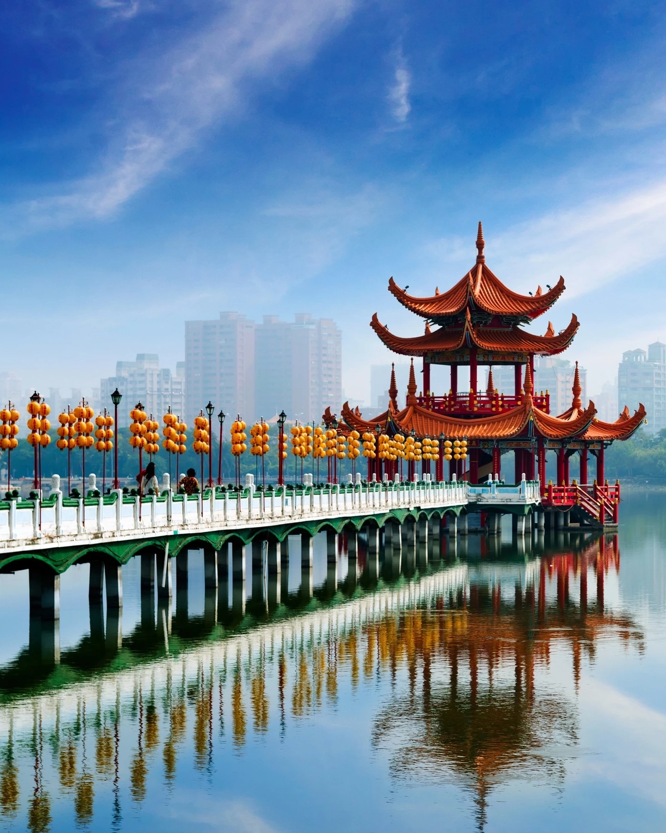 Bridge over water leading to red Wuliting Pagoda on the expansive Lotus Pond in Kaohsiung. Image credit: stock.adobe.com
