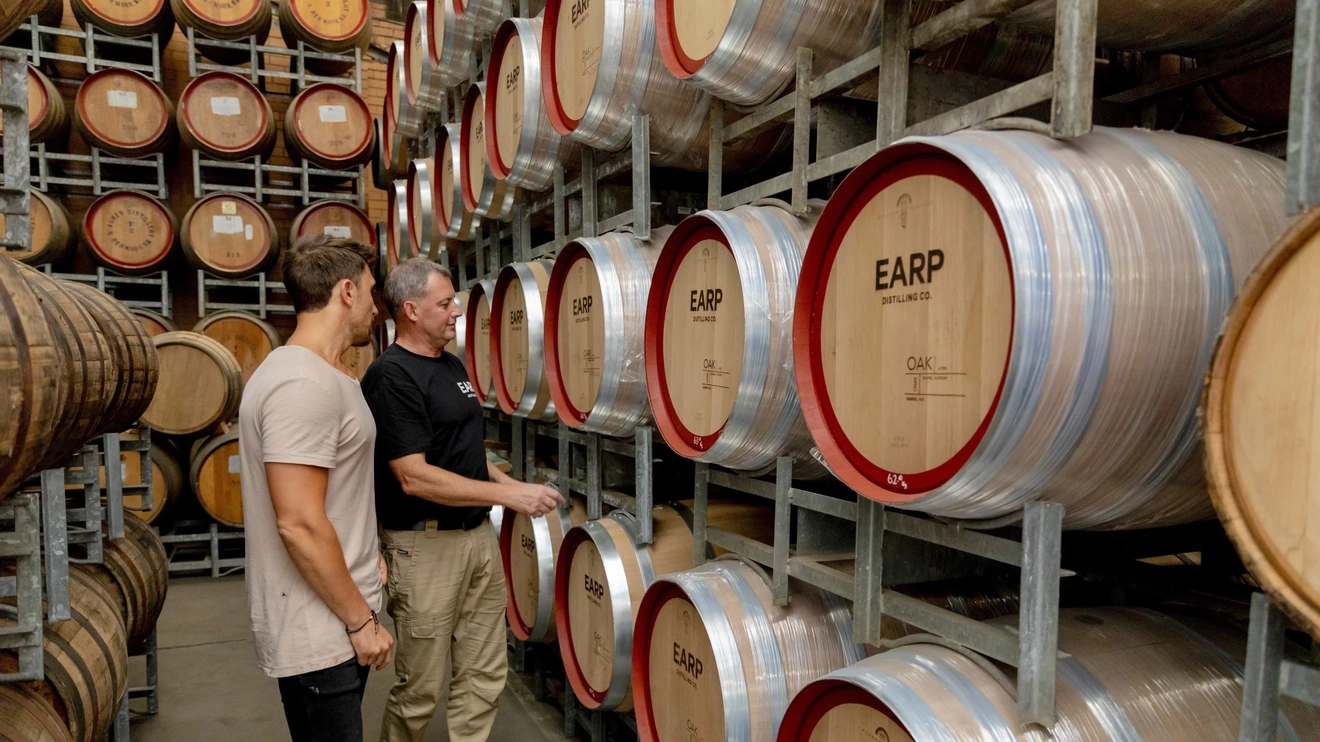 Barrels of gin and a distiller giving a visitor a tour at Earp Distilling Co., Carrington in Newcastle. Image credit: Destination NSW/Tyson Mayr