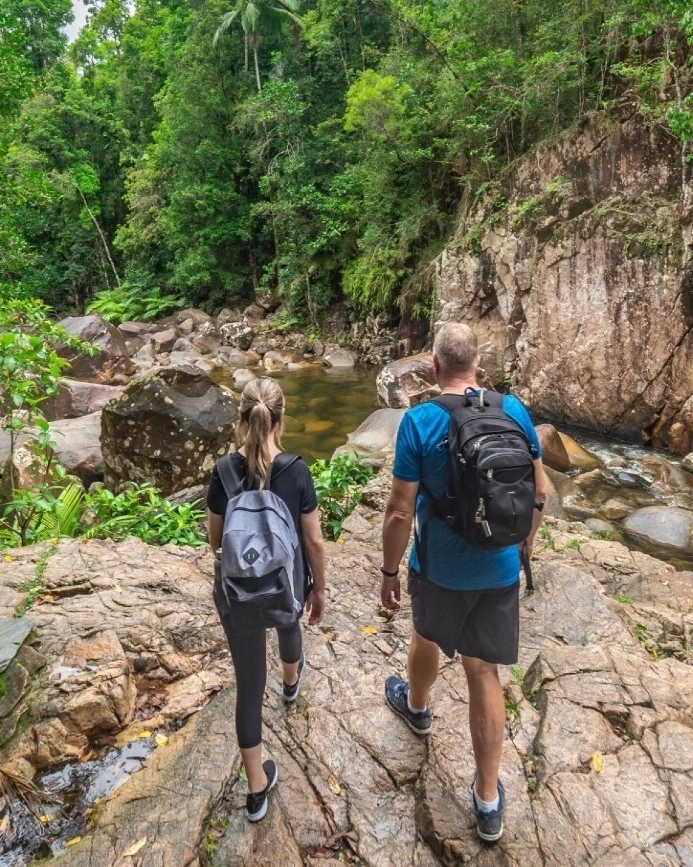 Two people hiking among boulders, rockpools and sub-tropical rainforest at Finch Hatton Gorge, Mackay area. Image credit: Tourism and Events Queensland