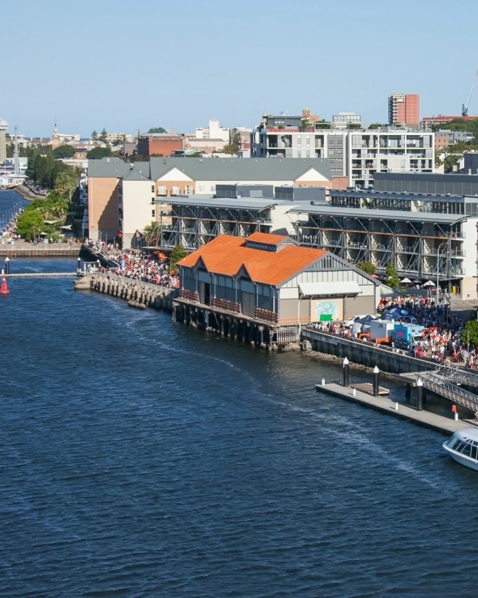 Aerial shot of buildings and promenade along the Hunter River in Newcastle. Image credit: Destination NSW