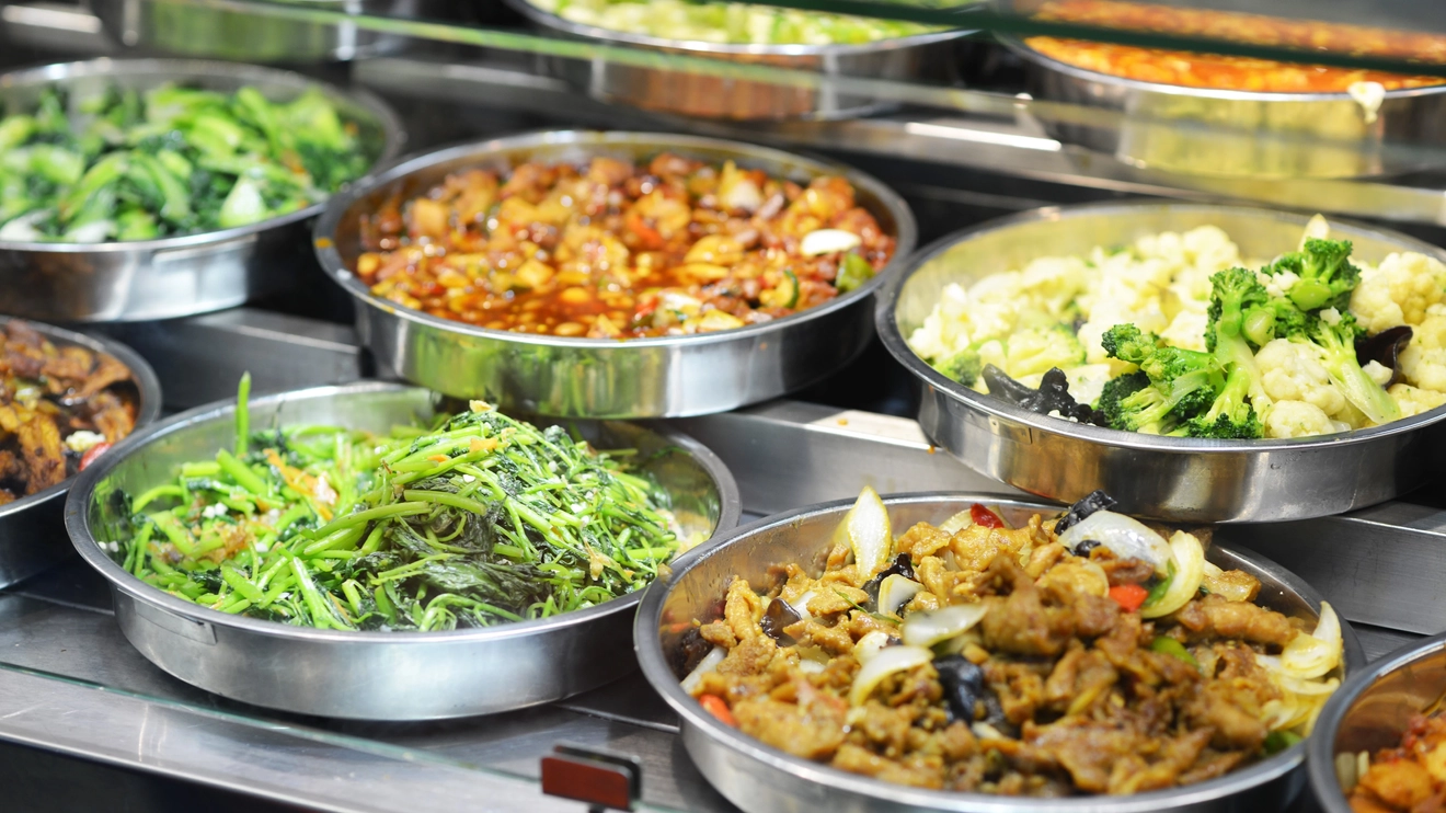 A close-up of metal trays laden with food at a hawker stand in Singapore. Image credit: stock.adobe.com