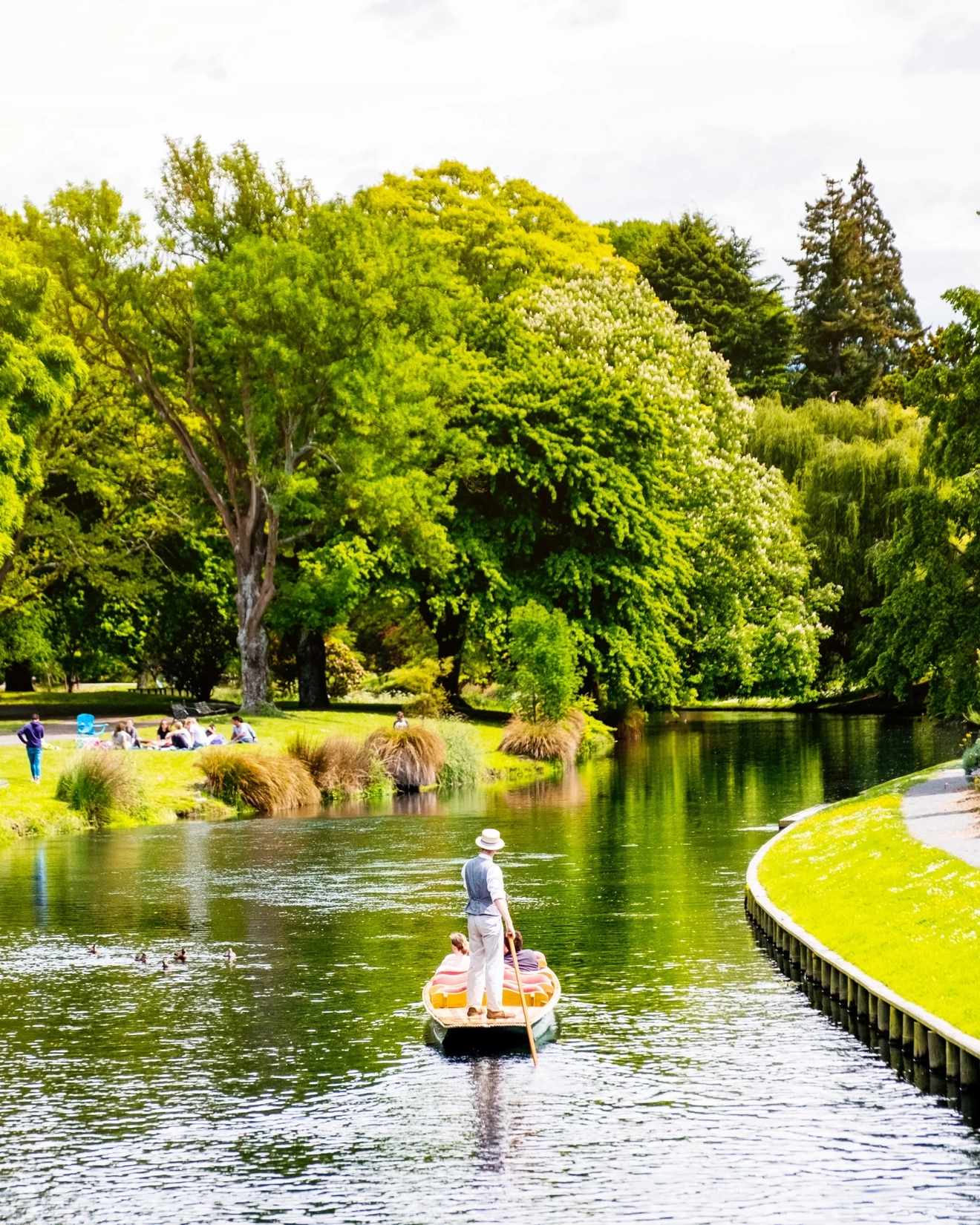 A punt with passengers floats down the Avon River through the Botanic Gardens, Christchurch, New Zealand. Image credit: stock.adobe.com