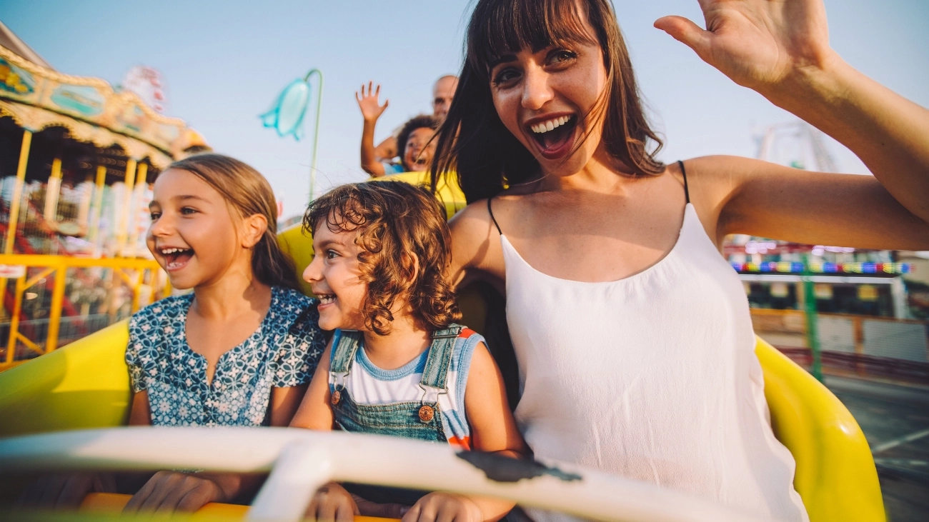 Young mum and her two toddlers on an amusement park ride, possibly at one of Australia's best family holiday destinations
