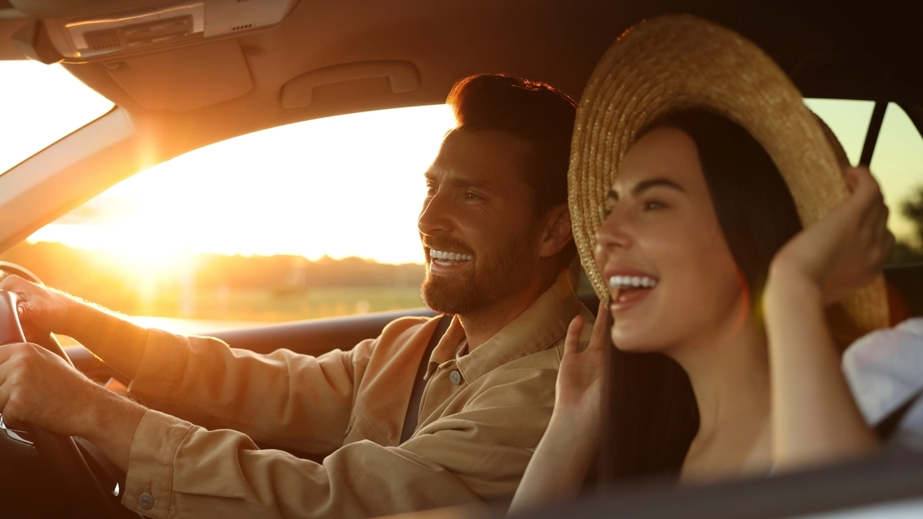 Smiling young couple in a Thrifty hire car