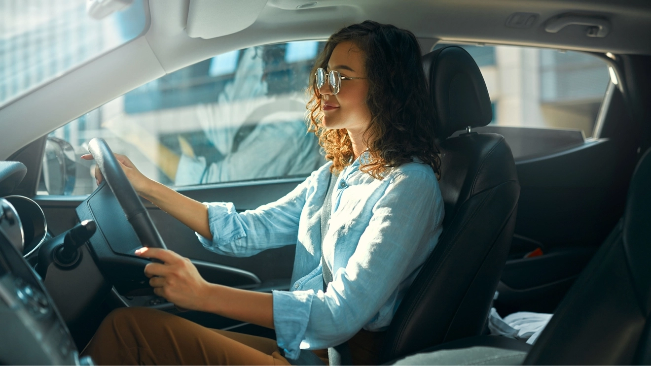 Young smiling woman drives a Thrifty hire car