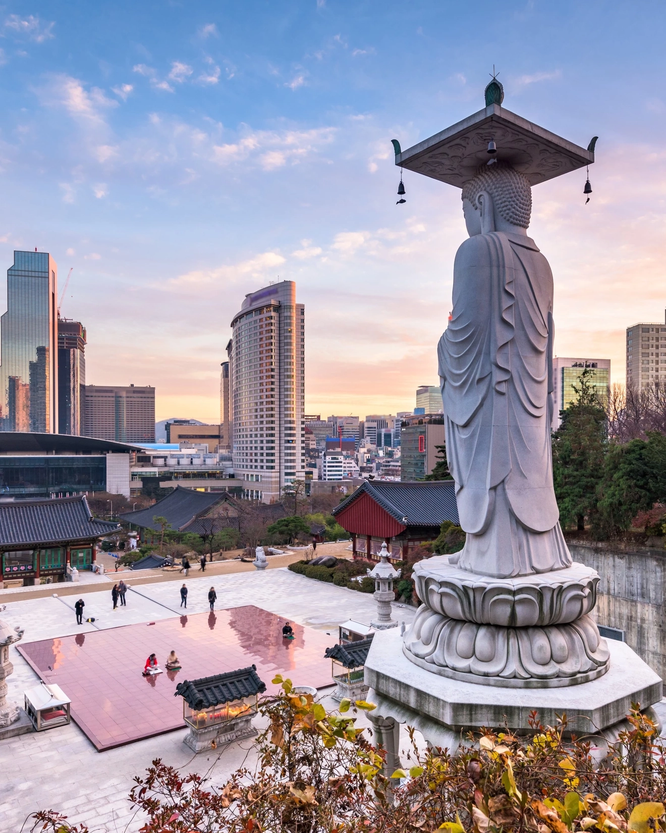 Buddhist statue at Bongeunsa Temple and Seoul city skyline, South Korea. Image credit: stock.adobe.com