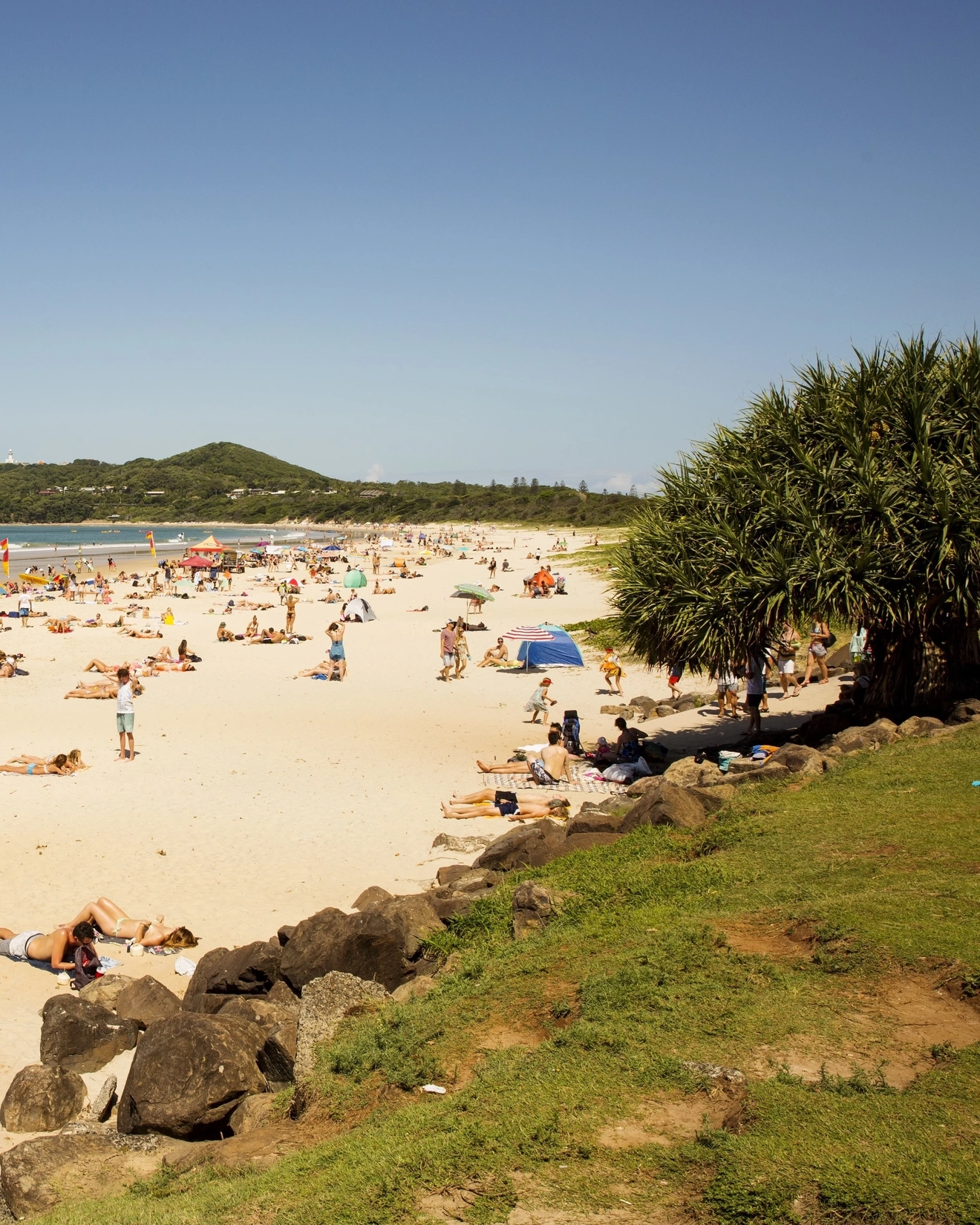 Crowds on the sand and in the water on a hot day at Main Beach, Byron Bay. Image credit: Destination NSW