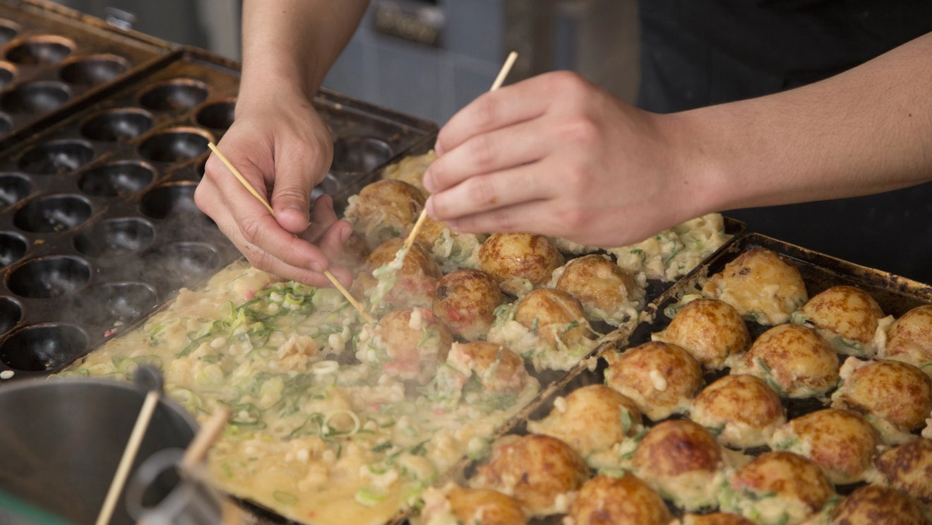 Street food vendor preparing takoyaki in Osaka, Japan. Image credit: stock.adobe.com
