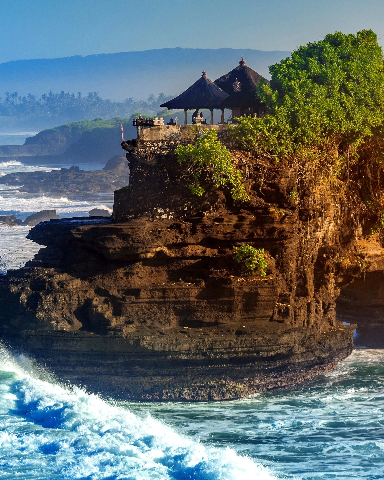Tanah Lot temple and coastline with crashing waves, Bali, Indonesia. Image credit: stock.adobe.com