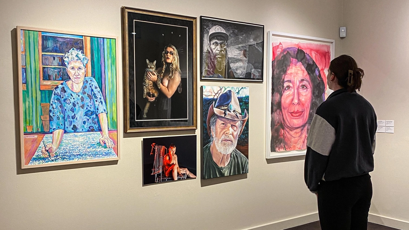 Woman looks at portraits from the Percivals at Perc Tucker Regional Gallery, Townsville. Image courtesy of Townsville City Council.